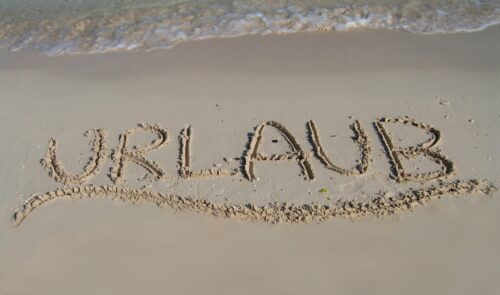 Urlaub Schriftzug Sand